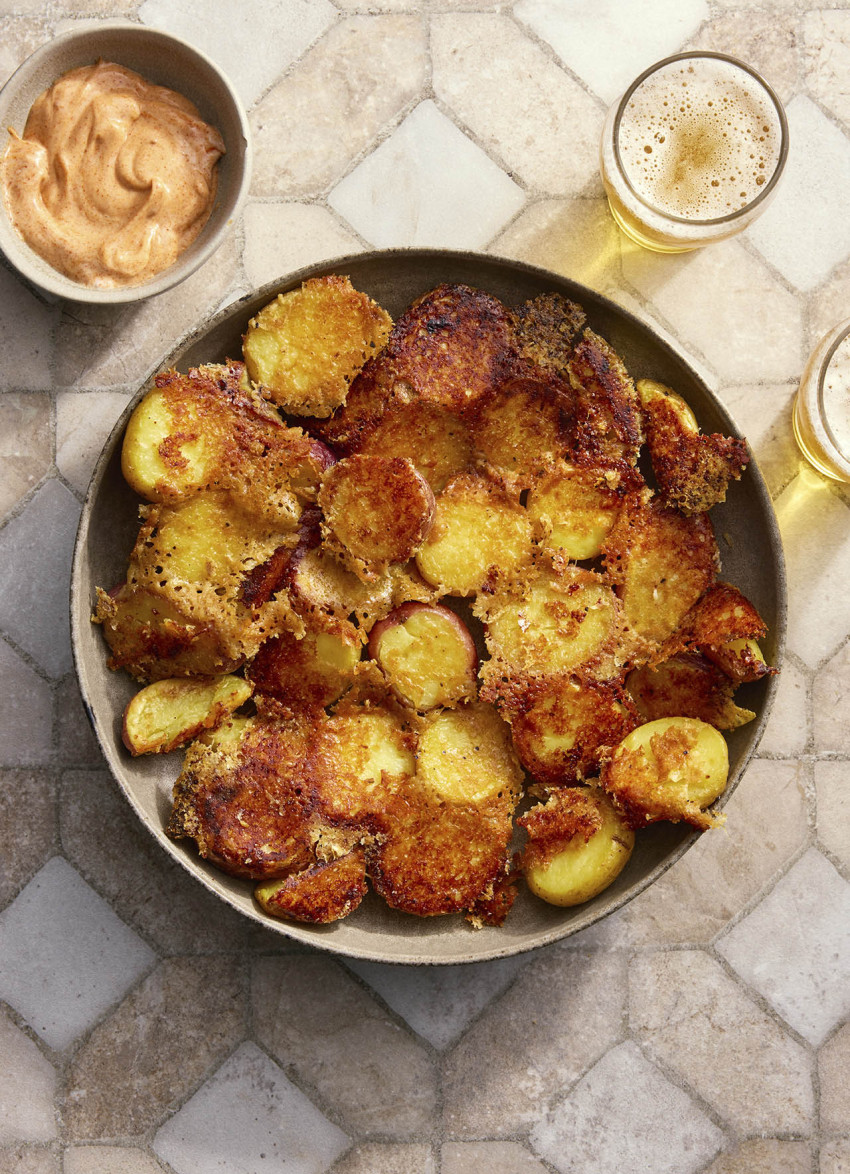Parmesan-crusted roast potatoes on a serving plate, golden and crispy